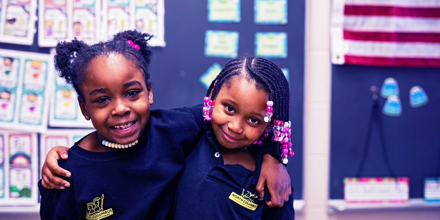 Smiling students with arms around each other.
